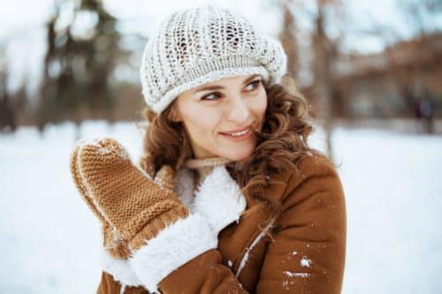 femme bien couverte contre le froid avec bonnet et gants en hiver