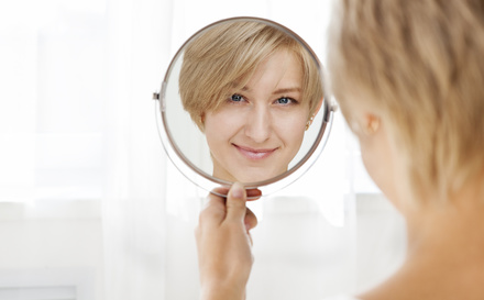 Femme qui sz regarde dans un miroir