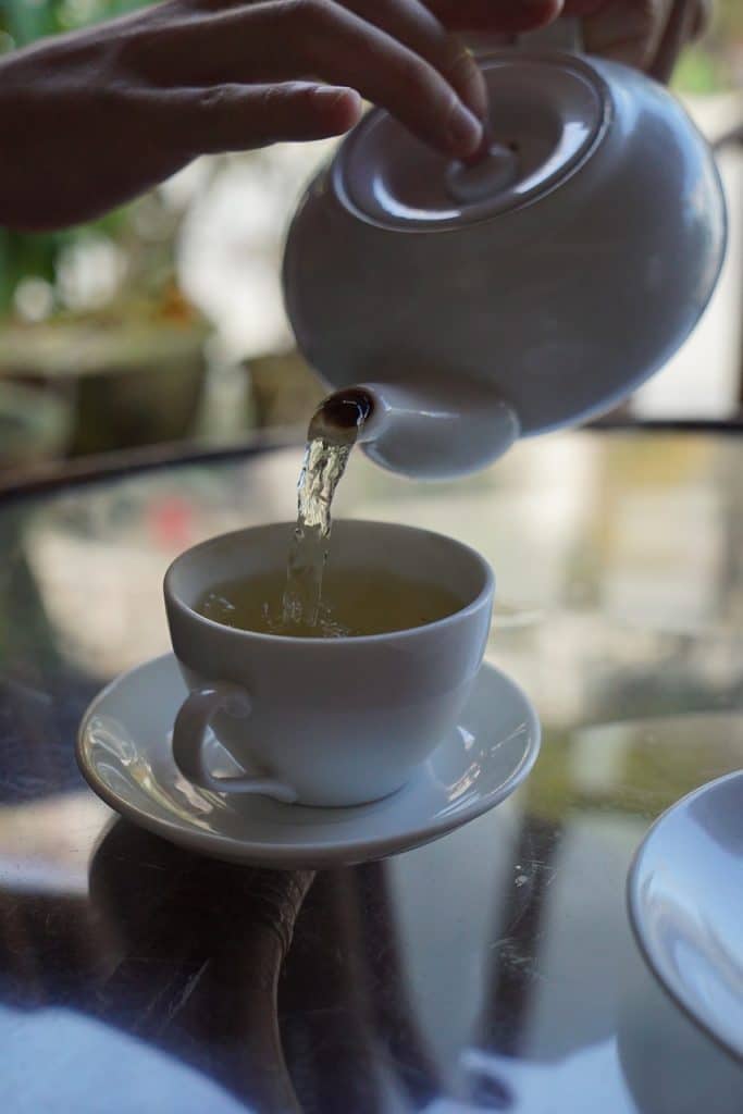 personne se servant une tasse de tisane