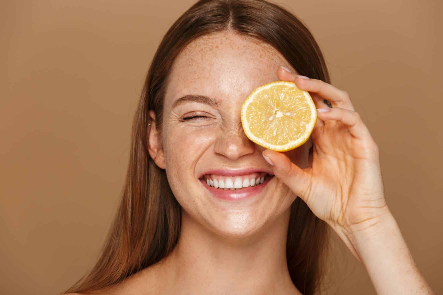 femme tenant une rondelle de citron